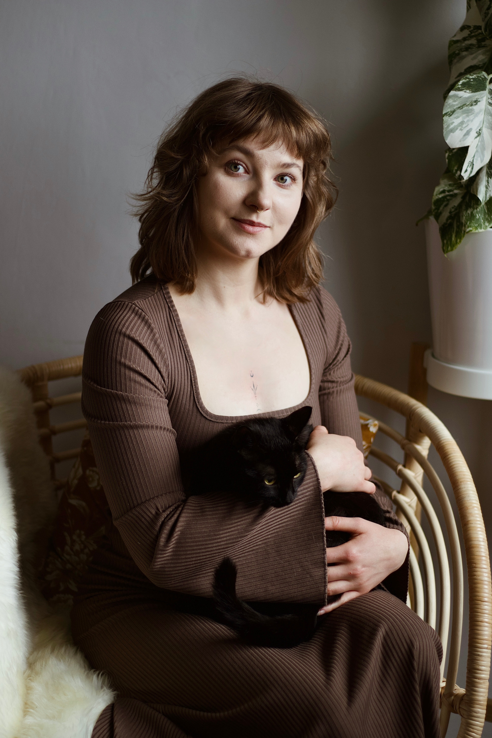 Kobieta pozująca do zdjęcia z czarnym kotem - felinoterapeutka, psycholożka, catsitterka, kocia behawiorystka i dietetyczka PsychoKocio